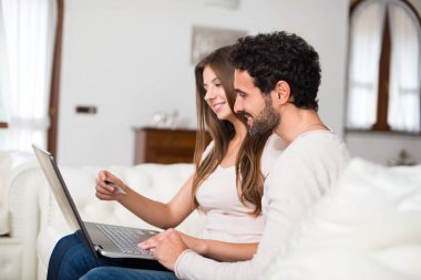 Çevrimiçi alışveriş yapmak için bir dizüstü bilgisayar kullanarak çift