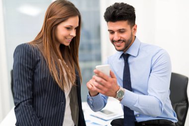 Dost işadamı için bir Bayan meslektaşım ofiste smartphone gösterilen