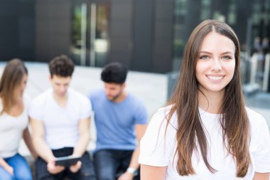 Arkadaşlar bir grup önünde gülümseyen kadın