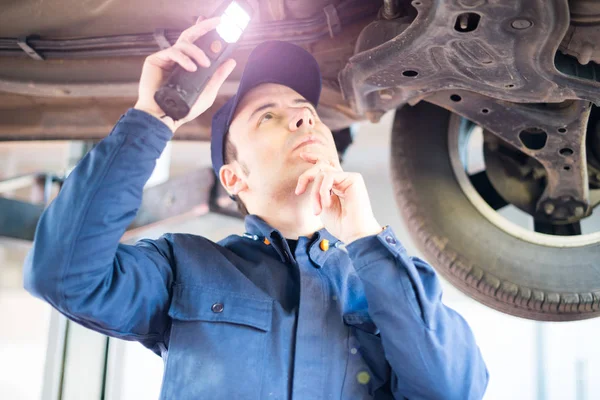 Mecánico Inspeccionando Coche Levantado — Foto de Stock