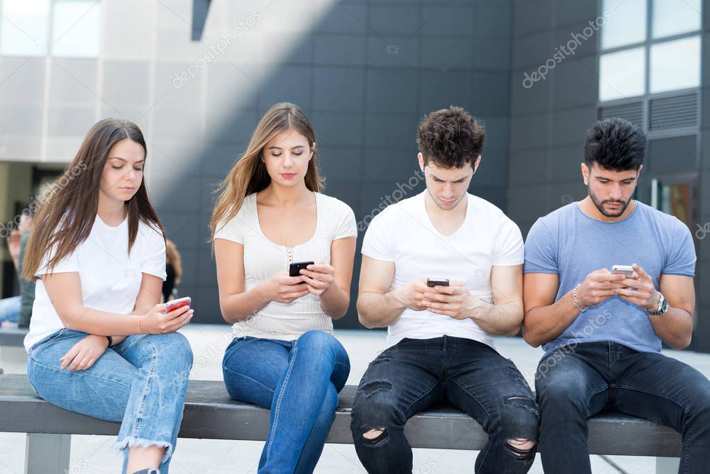 Group of friends ignoring each other due to mobile phones
