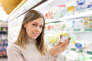 Gülümseyen müşteri bir ürün bir süpermarkette holding