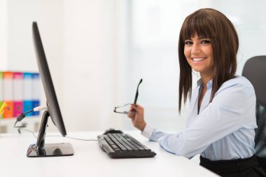Kadının önünde ofisinde bir masaüstü bilgisayar
