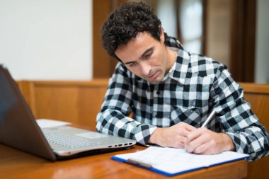 Evde onun dizüstü bilgisayar kullanan adam