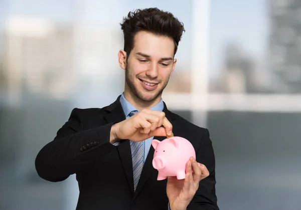 Jovem Empresário Bonito Colocando Dinheiro Banco Porquinho — Fotografia de Stock