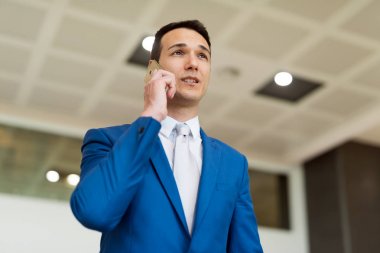 Genç işadamı telefonda konuşuyor.