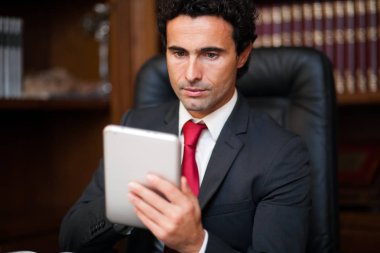 Tablet kullanarak Office yakışıklı bir işadamı portresi 