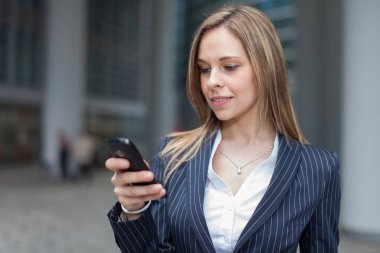 İş kadını cep telefonunu kullanıyor.