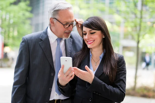 Uśmiecha Się Kobieta Jej Szef Pomocą Jej Telefon Komórkowy — Zdjęcie stockowe