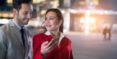 İş adamları birlikte cep telefonu kullanıyor.