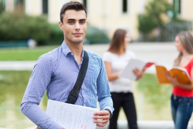 Dışarıdaki mutlu öğrenciler güvenle gülümsüyor.