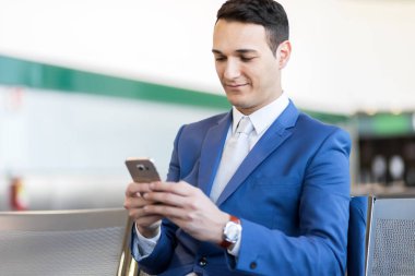 Havaalanındaki telefonu kullanan bir iş adamı.
