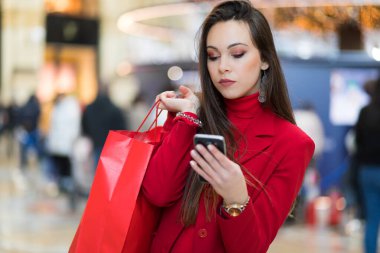 Bir akıllı telefon kullanırken Milan Milano'da alışveriş güzel genç turist kız