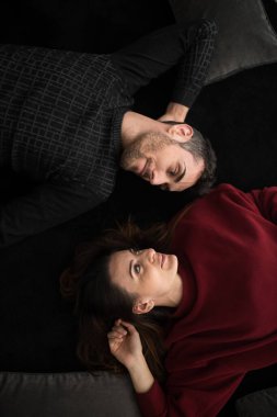 Mutlu genç çift evdeki halıda dinleniyor.