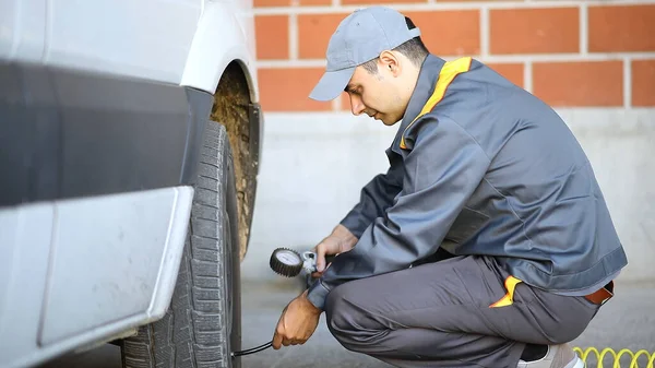 Smiling Mechanic Inflating Van Tire — Stock Photo, Image