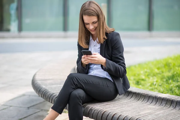 Usmívající Mladá Podnikatelka Pomocí Svého Mobilního Telefonu — Stock fotografie