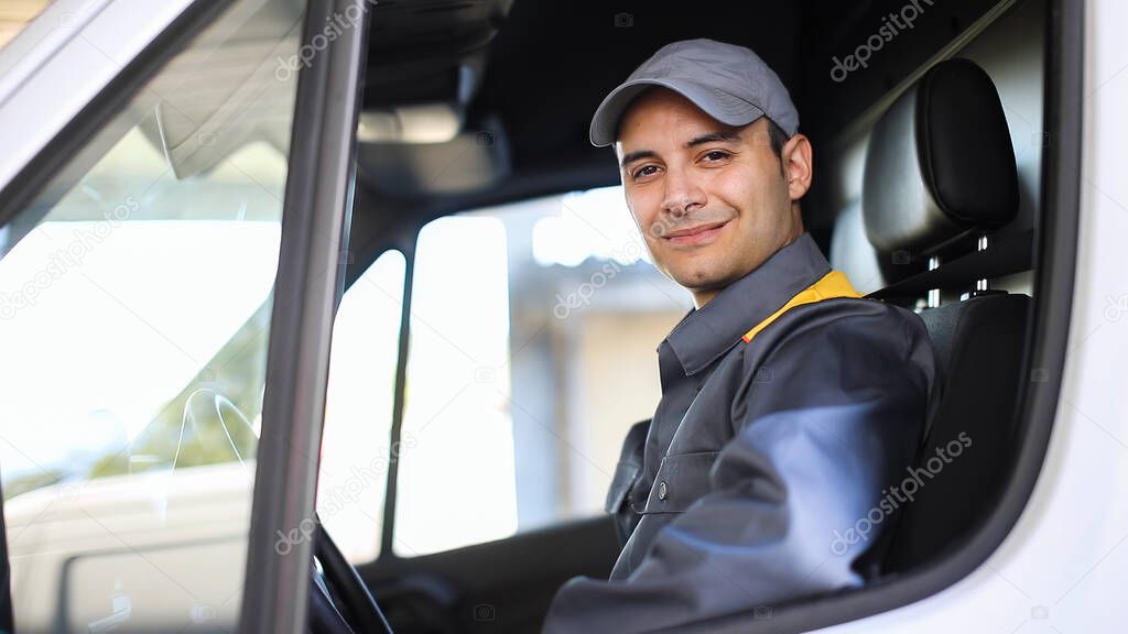 Smiling deliverer man driving a van