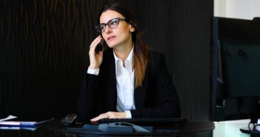 Genç sekreter ofisinde telefonda.