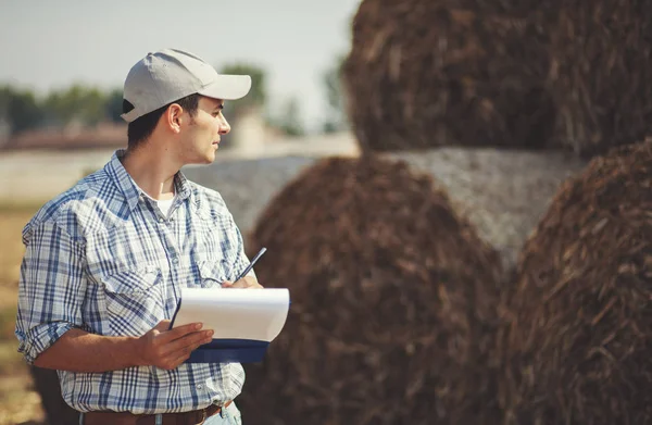 Farmer writing on a clipboard