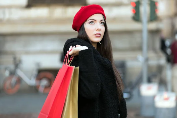 Mujer joven con bolsas de compras y regalo de Navidad en Milán, Italia —  Fotos de Stock