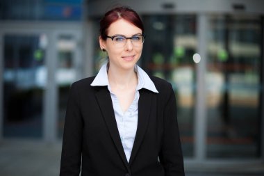 Modern bir şehir ortamında kendine güvenen genç bir bayan yönetici.