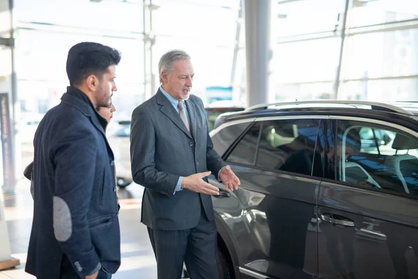 Jonge Familie Praat Met Verkoper Kiest Een Nieuwe Auto Een — Stockfoto