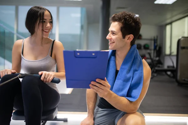 Young Woman Working Out Rowing Machine Personal Trainer Explaining Technique — Stock Photo, Image