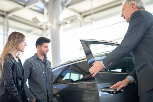 Jonge Familie Praat Met Verkoper Kiest Een Nieuwe Auto Een — Stockfoto