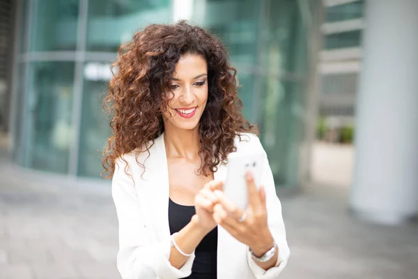 Smiling Businesswoman Using Her Mobile Cell Phone While Walking Outdoors — Stock Photo, Image