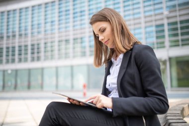 Ofisinden tablet kullanan genç bir kadının portresi.