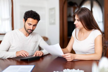 vergi, mali, Aile, ev ve mutluluk kavramı - kağıtları ve evde hesap makinesi ile meşgul Çift
