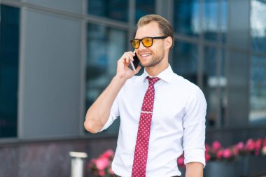 Cep telefonuyla konuşan genç ve yakışıklı bir işadamının portresi