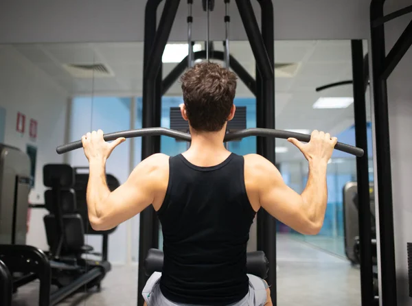 Hombre Usando Una Máquina Lat Gimnasio Para Entrenar Sus Hombros —  Fotos de Stock