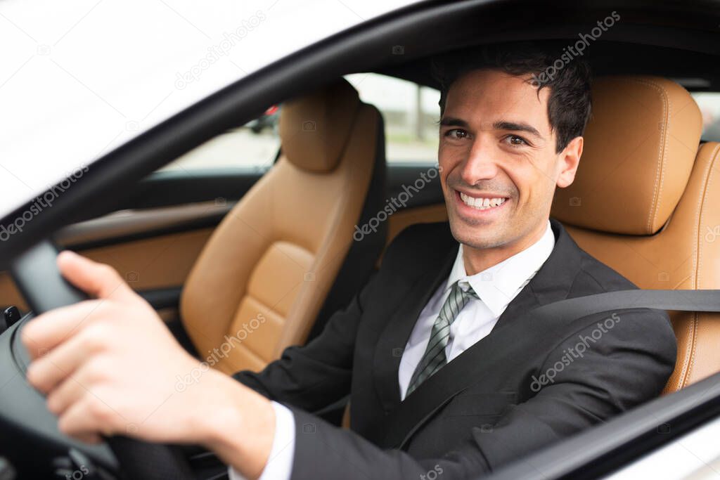 Smiling business man driving his new white car