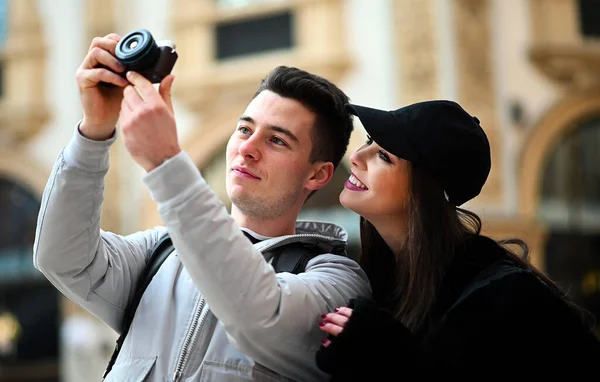 市内で写真を撮る観光客の若いカップル — ストック写真