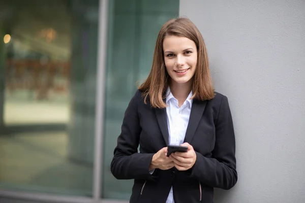 Lachende Jonge Zakenvrouw Met Behulp Van Haar Mobiele Telefoon — Stockfoto