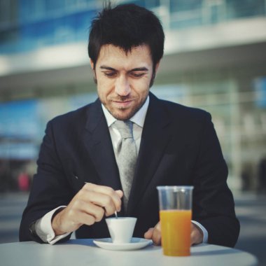 Yakışıklı iş adamı kahvaltı yapıyor.