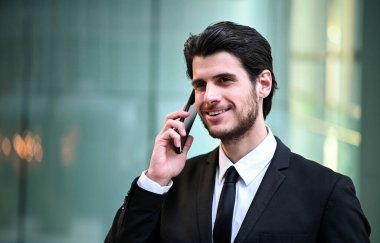 Şehir merkezinde genç bir yönetici telefonda konuşuyor.