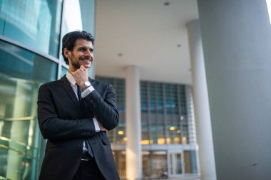 Modern bir iş ortamında gülümseyen bir iş adamının portresi.