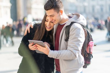 Genç turistler şehirde dijital tablet kullanıyorlar.