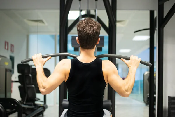 Hombre Usando Una Máquina Lat Gimnasio Para Entrenar Sus Hombros —  Fotos de Stock