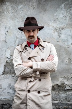 Gettoda kollarını kavuşturmuş bir dedektifin portresi.