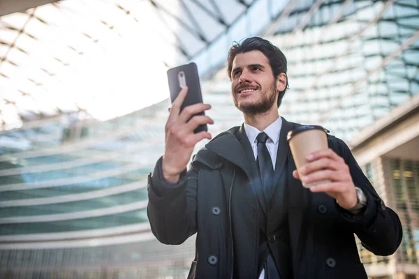 Podnikatel Sleduje Svůj Smartphone Při Pití Kávy — Stock fotografie