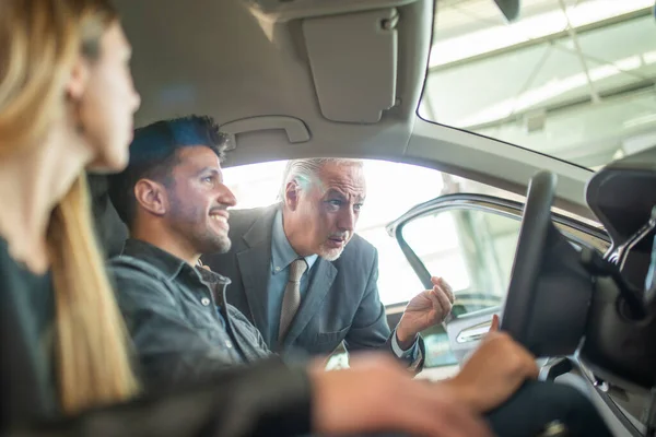 Feliz Joven Familia Hablando Con Vendedor Elección Nuevo Coche Una — Foto de Stock