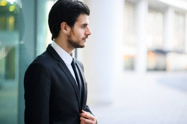 Genç iş adamı açık havada ciddi bir ifadeyle