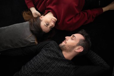 Mutlu genç çift evdeki halıda dinleniyor.