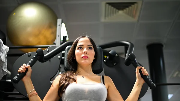 Woman using a chest press machine in a gym