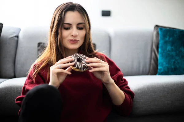 Mujer Joven Comiendo Donut Sentado Alfombra Cerca Sofá — Foto de Stock
