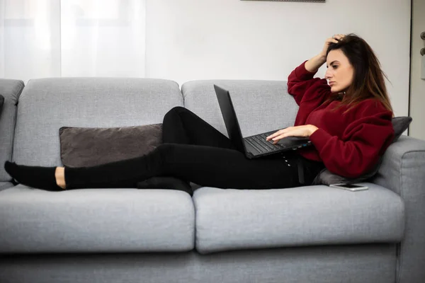 Vrouw Met Behulp Van Een Laptop Terwijl Ontspannen Bank — Stockfoto