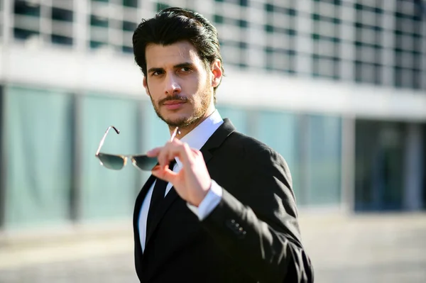 Fiatal Üzletember Egy Városban Napszemüveggel Kezében — Stock Fotó